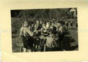 Hitlerjungen essen ihre Brotzeit im Freien