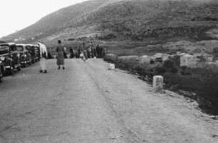 Reisefotos Mittelmeer. Straßenbild im arabischen Raum. Ansicht mit parkenden Autos, Einheimischem und Touristen