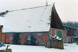 Voßkaten 6: giebelständiges Bauernhaus: Traufseite, Teilansicht: Wirtschaftstrakt mit Fachwerk, Kletterpflanzen: Giebelseite Wirtschaftstrakt mit Scheunentor: vorne Holzstapel: hinten rechts Wirtschaftsgebäude
