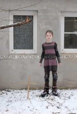 Mädchen auf Inline-Skates neben dem Grab ihres Kaninchens (Altersgruppe B)