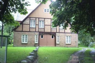 Dorfstraße 17: Bauernhaus: Giebelseite ehemaliger Wirtschaftstrakt mit Fachwerk: Scheunentor, Giebel mit Verbretterung
