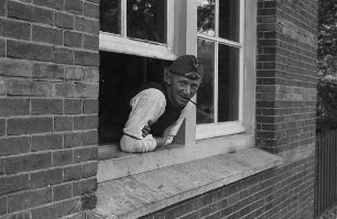 Zweiter Weltkrieg. Niederlande unter deutscher Besatzung. Porträt eines Wehrmachtsangehörigen, Pfeife rauchend und aus einem Fenster schauend (wohl bei Den Haag)