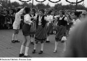 Tanzende Paare in Tracht bei einer Freiluft-Kulturveranstaltung