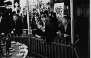 Jungen beim Ringwerfen auf dem Rummelplatz