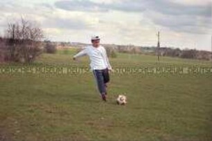 Fußballspielender Junge auf einer Wiese (Prämiertes Foto Sonderthema: Fußball-Fieber)