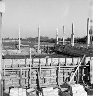 Sporteinrichtungen: Soltausredder: Sporthalle: Bau: vorn Holzverschalungen und Baumaterial: hinten Sportplatz und Bäume