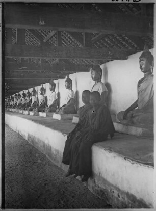 Tempel in Thailand : Thailand. Zwei Mönche in einer Galerie mit Buddhafiguren in einem Tempel, 1908/1913