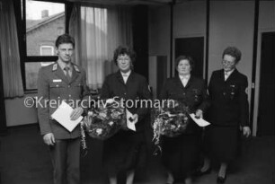 DRK-Ortsverein Reinfeld: Begegnungsstätte: Jahresversammlung: Ehrung der aktiven Mitglieder Ernst Hansen, Elfriede Rahmstorf, Telse Plautz mit Urkunden und Blumensträußen: rechts stellvertretende Vorsitzende Hiltraut Rösch: hinten Fensterfront und Türen