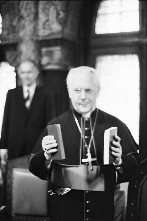 Freiburg: Erzbischöfliches Ordinariat, Dr. Herder übergibt Erzbischof Dr. Schäufele [neues] Gesamt-Gesangbuch [Gotteslob]