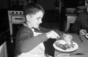 Freiburg: Adelhauser Schule; Jungen lernen Kochen; Bub mit Pfannkuchen