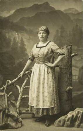 [Porträt einer Frau in gemustertem Kleid mit Schürze]