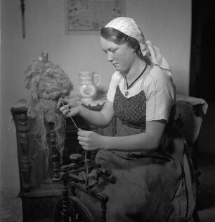 Junge Frau in Wachauer Arbeitstracht am Spinnrad