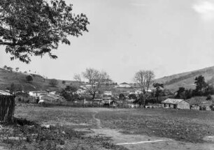 Fußballplatz : Blick über den Fußballplatz in Lindóia, dahinter die Häuser des Ortes. Hinter einem Fußballtor weiden Tiere.