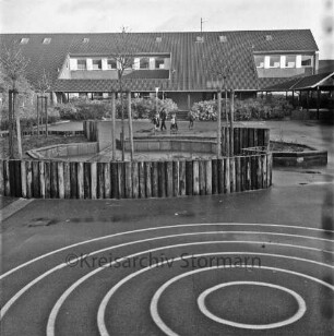 Hoisbüttel: Lottbek: Grund- und Hauptschule Hoisbüttel: Teichweg: Schulhof mit "Sitzrund"-Anlage: hinten Schüler: dahinter Sträucher und Schulgebäude