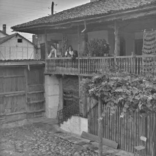 Veranda eines Wohnhauses in Bansko. Frauen in bulgarischer Tracht