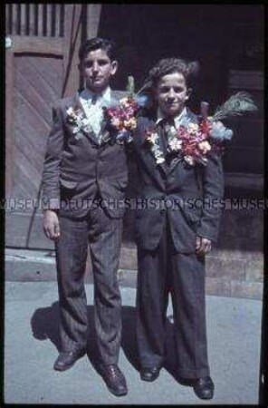Zwei Jungen im Anzug mit Blumenschmuck am Reverse