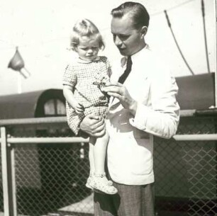 Der Bordfotograf Franz Grasser mit "Mausi", der Tochter eines Kapitäns, dem Deck eines Passagierschiffes (eventuell Monte Rosa)