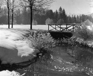 Winterbilder. Verschneite Landschaft mit Bachlauf und Brücke