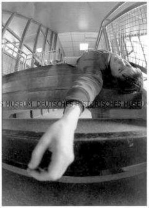 Junge liegt auf der Treppe, ein Arm hängt herunter (Altersgruppe bis 14)