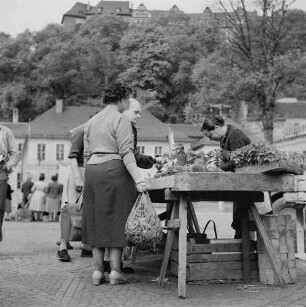 Greiz. Frauen stehen an einem Gemüsestand auf dem Wochenmarkt