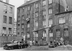 Hamburg-St. Pauli. Hinterhöfe in der Talstraße. Kinder spielen mit einem abgestellten Autowrack