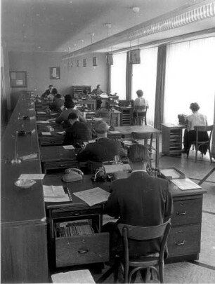 In einem Großraumbüro. Angestellte arbeiten an Büromaschinen