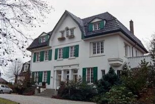 Hamburger Straße 84: traufständiges Landhaus: Straßenfront mit Eingangsportal mit Säulen, Freitreppe, Sprossenfenster mit Fensterläden, mittiger Zwerchgiebel: links Anbau: rechts Anbau mit Altan: davor Auffahrt: 17. November 1998