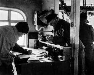Eintragung von Positionen : Lieutnant Edward Smith (1889-1961) und Fleming im Navigationsraum des Luftschiffs beim Eintragen von Positionen.
