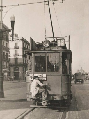 Barcelona. Spanien. Ein "blinder Passagier" sitzt auf dem Puffer einer Straßenbahn. Geld sparen der besonderen Art