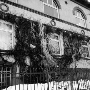Kerns Internatsschule (Realschule): Königstraße: vorn Zaun: dahinter Hauswand mit Rankgewächs: darauf Eiszapfen in Form eines Wasserfalls: Winter