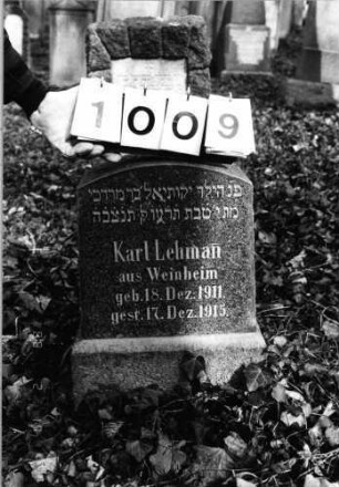 Grabstein 1009 (Index: 99803874) Material: Granitplatte, poliert Zustand: sehr gut Maße HxBxT: 57x33x14 cm Beschreibung: Sockel, Stele mit Flachbogenabschluß: Grabstein 1009