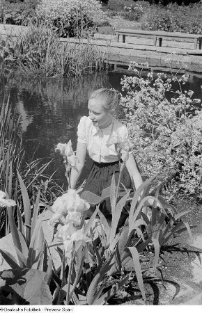 Mädchen, an einem Ufer sitzend