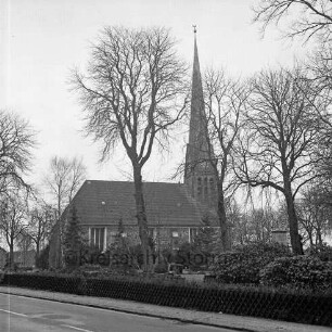 Friedenskirche: Außenansicht von Nordosten: im Vordergrund Kirchhof mit Bäumen: davor Hauptstraße