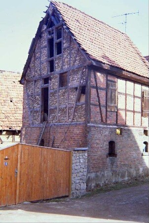 Wirtschaftsgebäude mit Bauschäden am Giebel und Dach; neues Hoftor