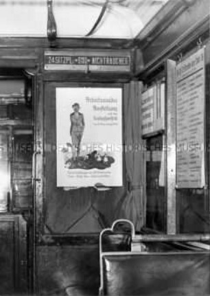 Plakatwerbung für die Ausstellung "Arbeitsmaiden" in einer S-Bahn