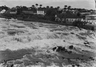 Wasserfall des Piracicaba : Ein Wasserfall des Piracicaba mit Stromschnellen und Felsen im Flussbett. Im Hintergrund die Häuser der gleichnamigen Stadt.