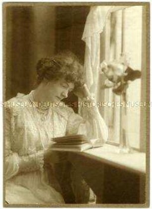 Florentine Fleischhut mit einem Buch am Fenster sitzend