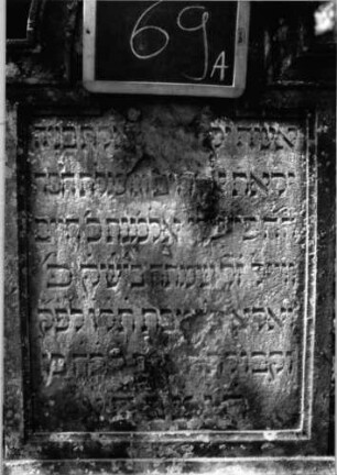 Grabstein 69 (Index: 100090677) Material: Sandstein Zustand: abgeblättert mit Textverlust Maße HxBxT: 118x53x14 cm Beschreibung: Stele, profiliert. Sockel, eingezog. Rundbogenabschl. m. Verdach. , Schrift eingetieft: Grabstein 69A