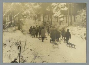Kinder mit Schlitten im Winterwald