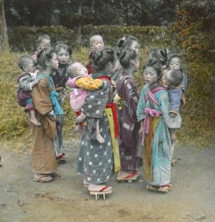 Japan. Japanische Mädchen und Frauen im Kimono mit Kleinkindern auf dem Rücken