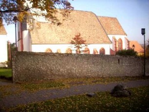 Ansicht von Süden mit Kirche (Gotischer Neubau) über Kirchhofmauer (Wehrgang mit Steinbrüstung abgetragen)-erhaltene Schießscharte (Schlitzscharte) in Brusthöhe