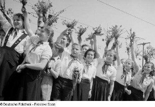 Mit Blumensträußen winkende Pioniere auf dem Karl-Marx-Platz