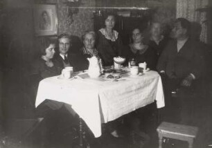 Familienfoto an einer Kaffeetafel in einem Wohnzimmer