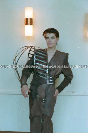Modell (Sabine von Oettingen) in einem braunen Lederkleid mit Metallbändern der Designergruppe Allerleirauh