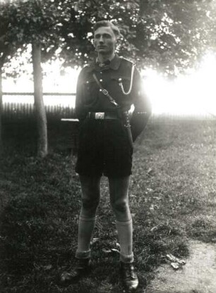 Deutsches Jungvolk. Jungstammführer mit weißer Führerschnur (Dienststellung), bestätigter Fähnleinführer (= Dienstrang) aus dem GAU Sachsen-Mitte mit Parteiabzeichen der NSDAP und dem Abzeichen für eine Prüfung in der Marine-HJ; mit Schulterriemen, Koppelschloss und Fahrtenmesser in Übergangsuniform (für Frühjahr und Herbst), mit Winterjacke und kurzer Hose