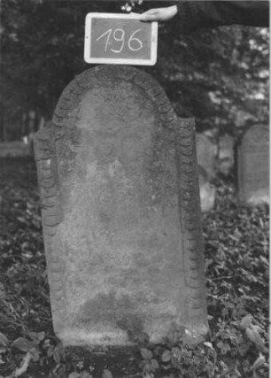Grabstein 196 (Index: 99894778) Material: Sandstein Zustand: gänzlich verwittert und abgeblättert Maße HxBxT: 106x58x8 cm Beschreibung: Stele mit eingezogenem Rundbogenabschluss Symbolik: Schuppenmuster: Grabstein 196