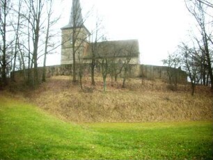 Ansicht von Norden mit Kirche (im Kern frühgotisch) über Kirchhofmauer (Wehrgang mit Steinbrüstung im 19 Jh abgetragen) in erhöhter Lage