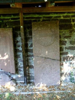 Hirsau-Kloster St Peter und Paul-Klosterbereich im Nordosten-ehemaliger Mönchsfriedhof-Grabstein an der Klostermauer aus dem zerstörten Friedhof-beschädigt (15-17 Jh)