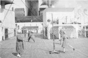 Passagiere beim Tennis und Swingball-Spiel an Deck des Hochseepassagierdampfers "Bremen"