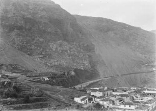 Siedlung am Hang : Blick von einer Anhöhe auf eine Siedlung, die an einem Hang liegt. Auf dem Hang vereinzelte Ackerflächen